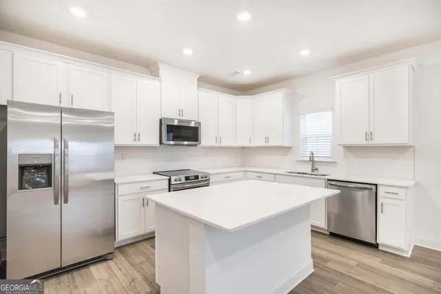 a kitchen with a refrigerator sink and cabinets