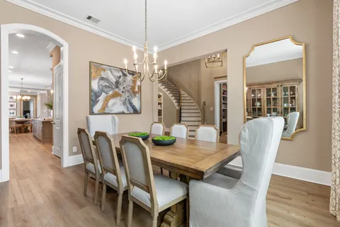 a dining room with furniture a chandelier and wooden floor