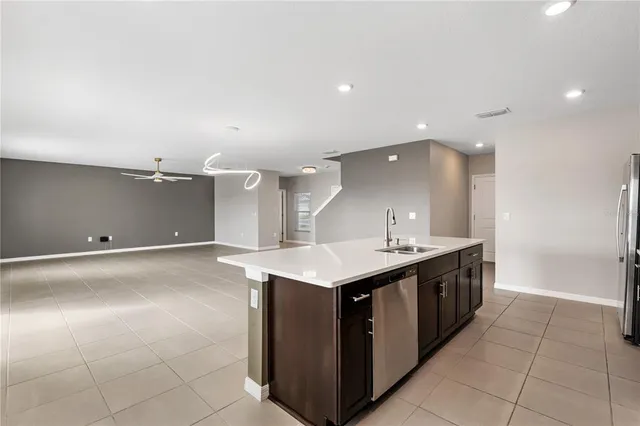 a kitchen with a sink and a stove top oven with wooden floor
