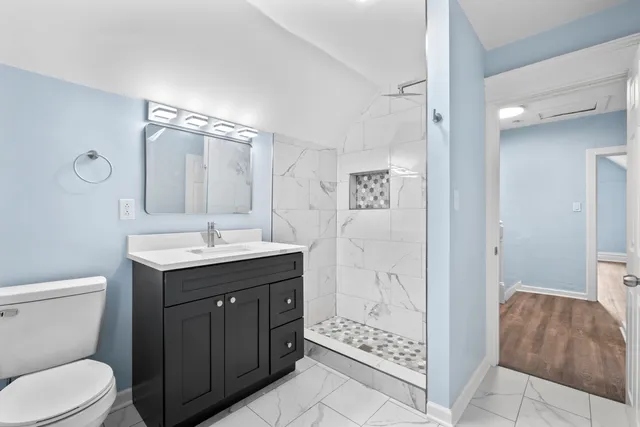 a bathroom with a sink toilet vanity and shower