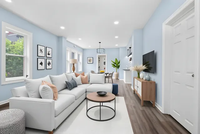 a living room with furniture a flat screen tv and a window