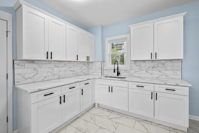 a sink with white cabinets