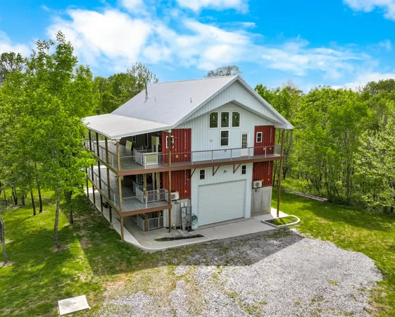 a view of a big house with a big yard and large trees