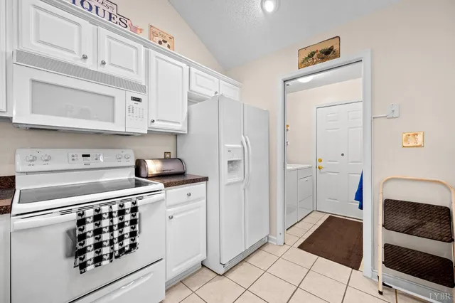 a kitchen with white cabinets and appliances