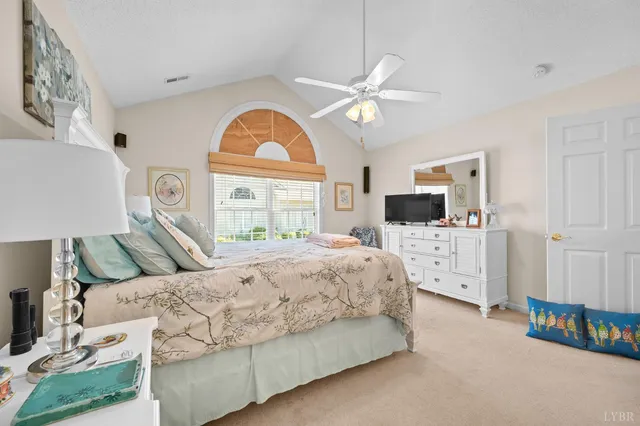 a bedroom with a bed a dresser and a flat screen tv