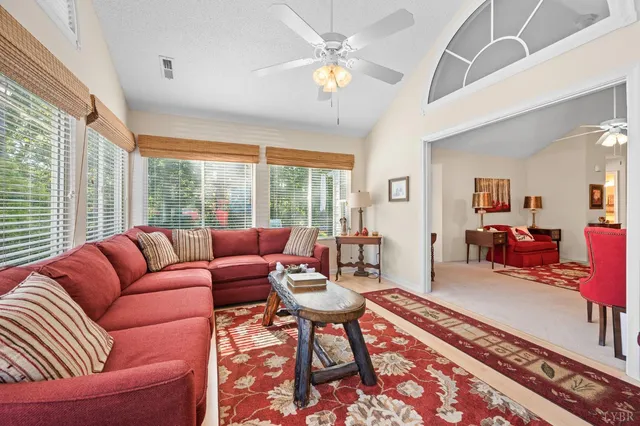 a living room with furniture and a floor to ceiling window