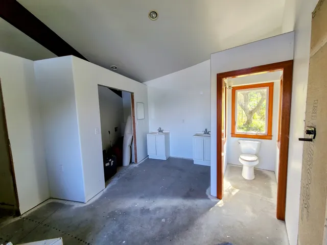 a view of a hallway with toilet and a tub