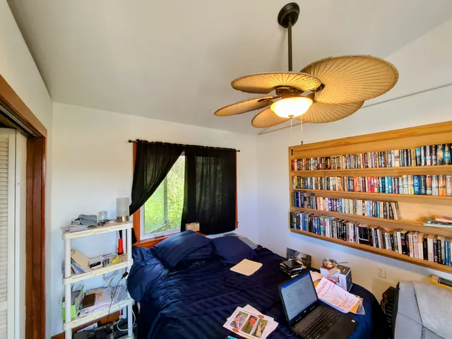 a bedroom with furniture and a large window