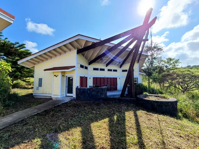 a view of a house with backyard and sitting area