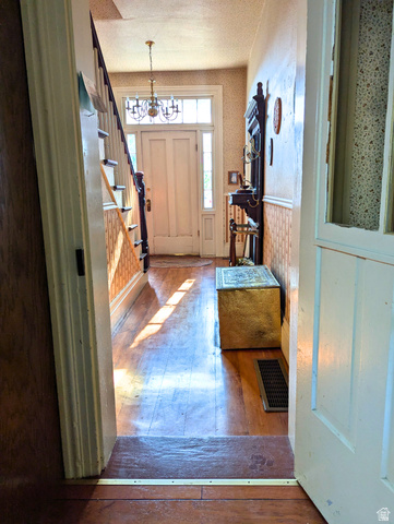 190 North 200 E Street Beaver, UT 84713 - Photo 22 of 40 Foyer featuring hardwood flooring, a white two-panel entry door with sidelights, transom window, and a chandelier