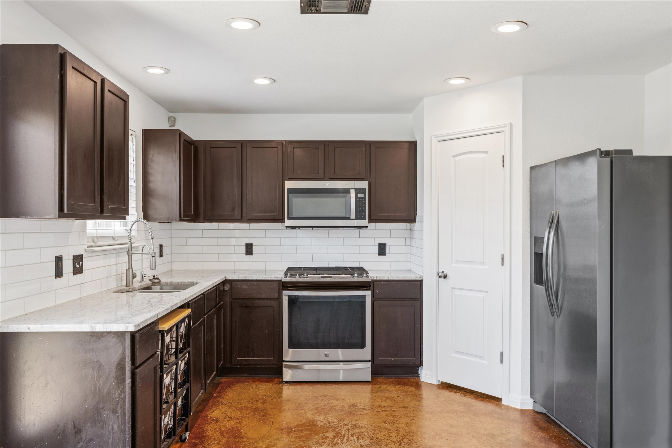 4516 Kind Way, Unit 253 Austin, TX 78725 - Photo 6 of 31 a kitchen with a sink stainless steel appliances and cabinets