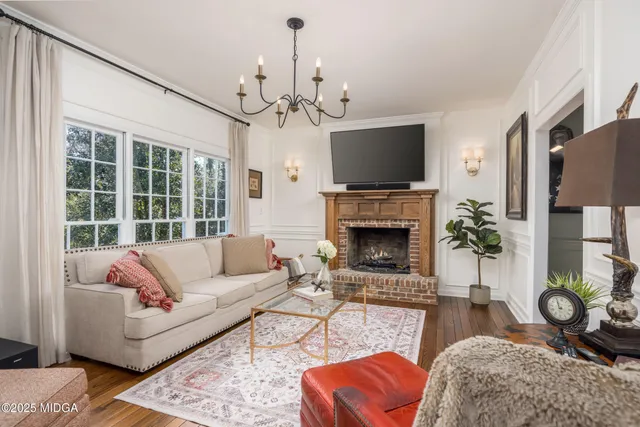 a living room with furniture a fireplace and a chandelier