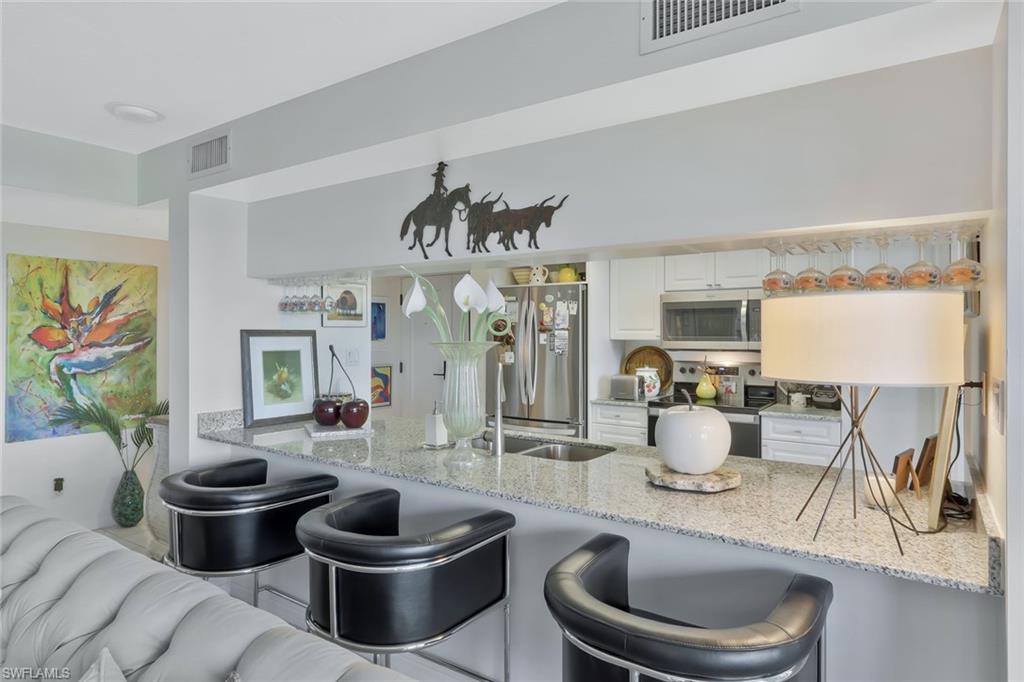 6573 Marissa Loop, Unit 303 Naples, FL 34108 - Photo 9 of 31 a living room with furniture and a painting on the wall