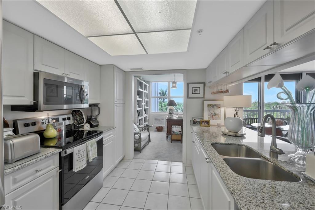 6573 Marissa Loop, Unit 303 Naples, FL 34108 - Photo 10 of 31 a kitchen with stainless steel appliances granite countertop a sink dishwasher stove and refrigerator