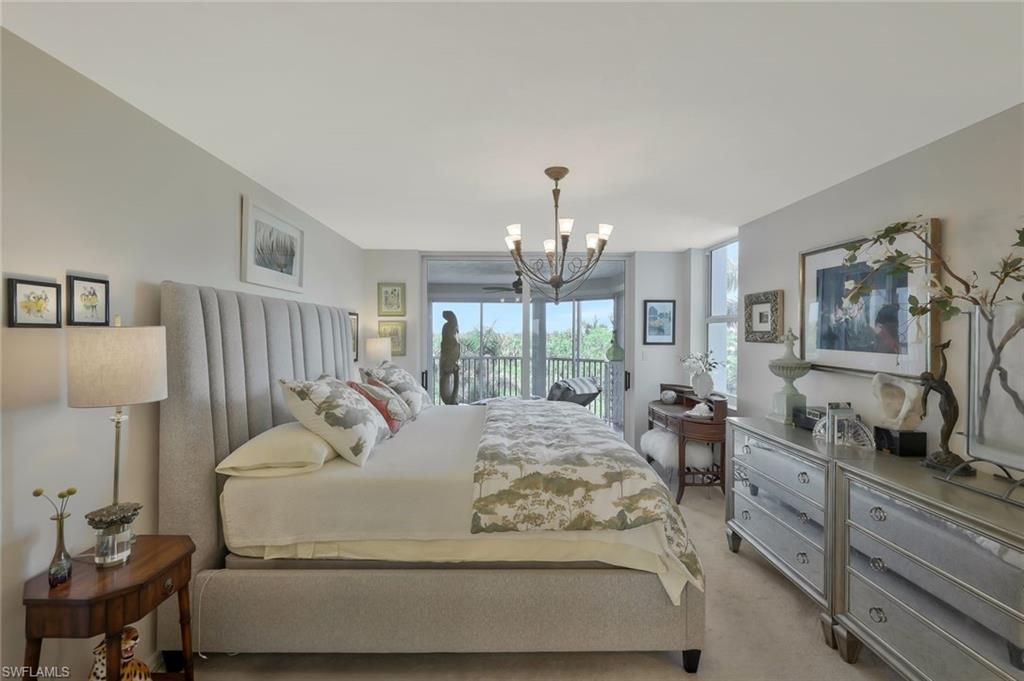 6573 Marissa Loop, Unit 303 Naples, FL 34108 - Photo 11 of 31 a living room with furniture and a chandelier