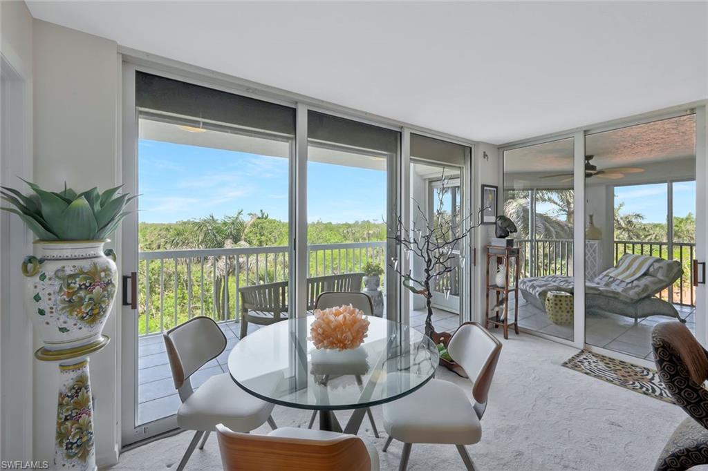 6573 Marissa Loop, Unit 303 Naples, FL 34108 - Photo 23 of 31 a living room with furniture and a floor to ceiling window