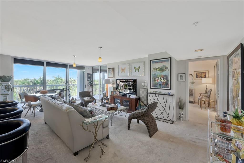 6573 Marissa Loop, Unit 303 Naples, FL 34108 - Photo 7 of 31 a living room with furniture and a large window