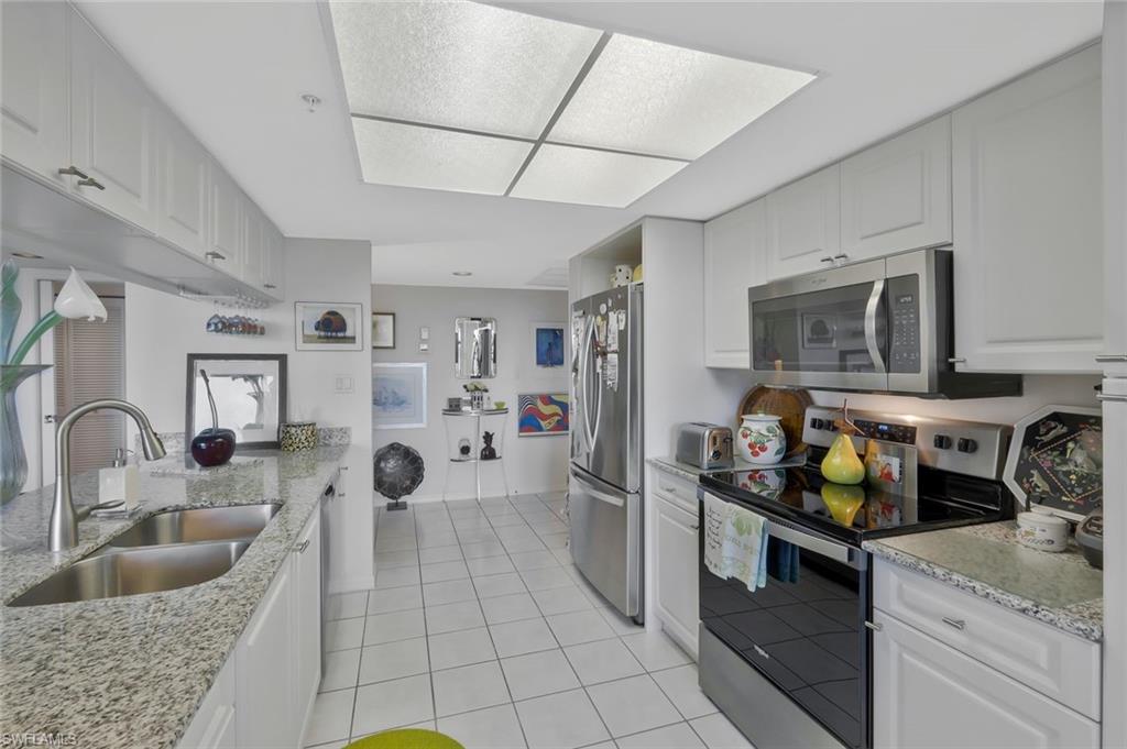 6573 Marissa Loop, Unit 303 Naples, FL 34108 - Photo 8 of 31 a kitchen with stainless steel appliances granite countertop a sink and a counter space