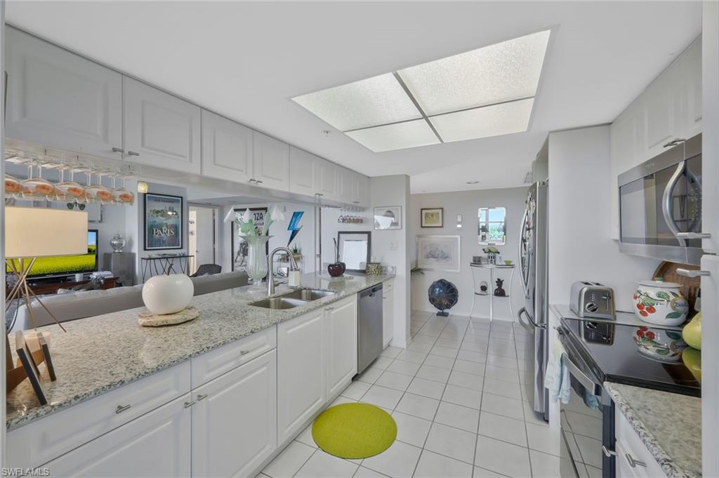 6573 Marissa Loop, Unit 303 Naples, FL 34108 - Photo 31 of 31 a bathroom with a granite countertop sink mirror and vanity