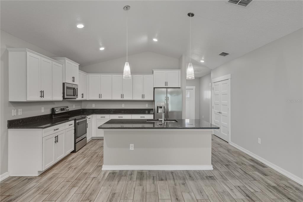 13907 9th Street Dade City, FL 33525 - Photo 11 of 43 a kitchen with stainless steel appliances granite countertop a sink and cabinets