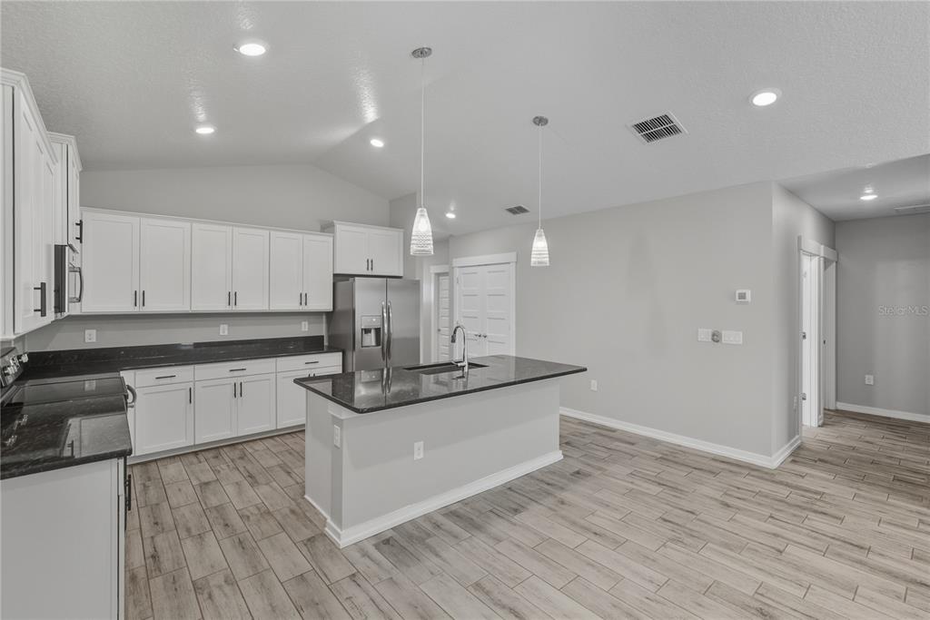 13907 9th Street Dade City, FL 33525 - Photo 12 of 43 a kitchen with stainless steel appliances granite countertop a sink and cabinets