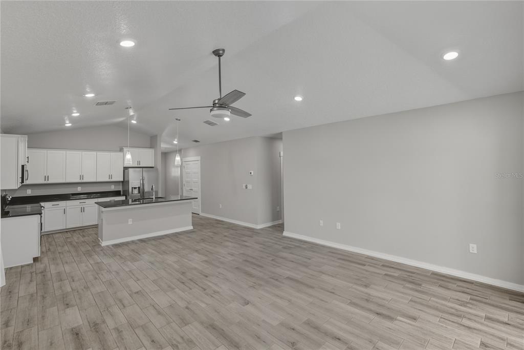 13907 9th Street Dade City, FL 33525 - Photo 18 of 43 a large kitchen with stainless steel appliances a large counter top a stove and a wooden floors