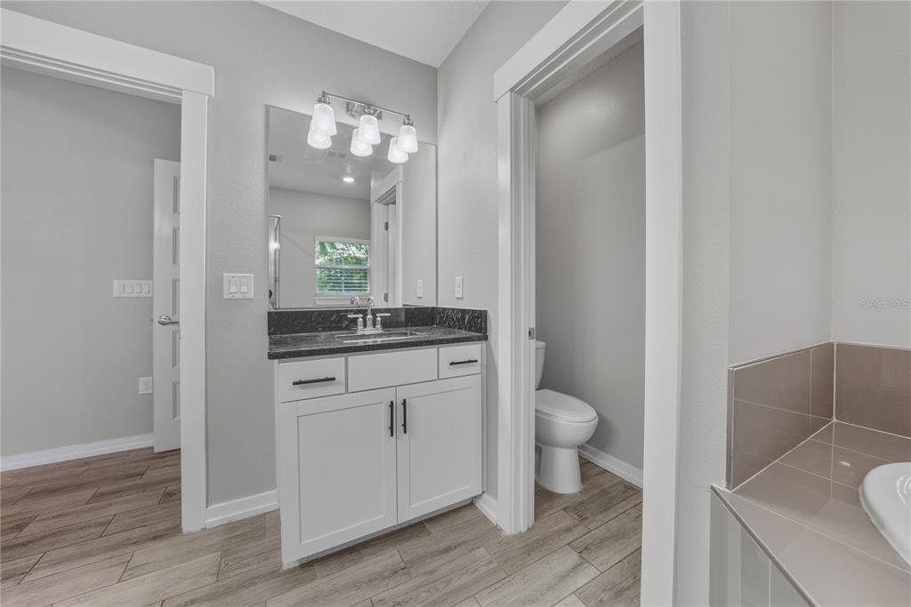 13907 9th Street Dade City, FL 33525 - Photo 26 of 43 a bathroom with a granite countertop sink toilet and mirror
