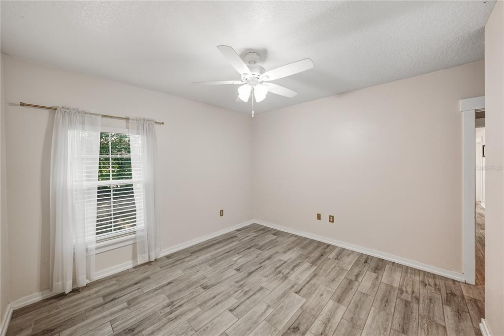 13907 9th Street Dade City, FL 33525 - Photo 29 of 43 an empty room with wooden floor and windows