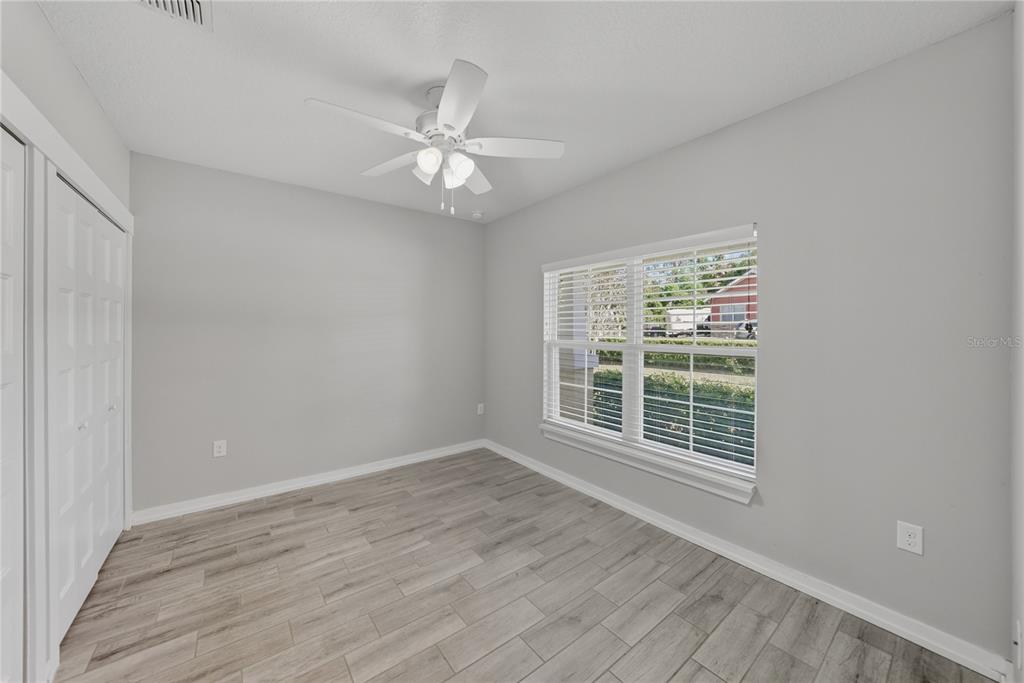 13907 9th Street Dade City, FL 33525 - Photo 32 of 43 a view of an empty room with a window and wooden floor