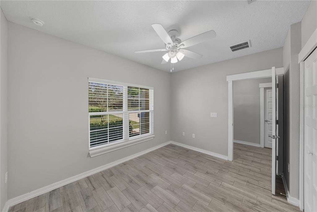 13907 9th Street Dade City, FL 33525 - Photo 34 of 43 a view of an empty room with a window and wooden floor