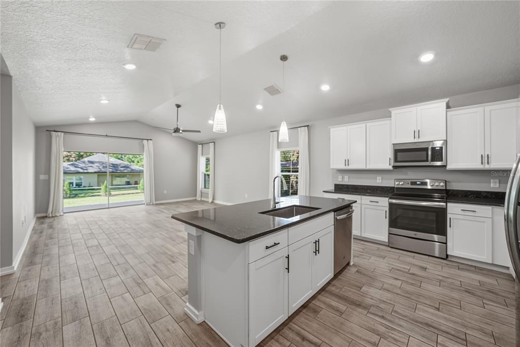 13907 9th Street Dade City, FL 33525 - Photo 9 of 43 a kitchen with stainless steel appliances granite countertop a stove a sink and a refrigerator
