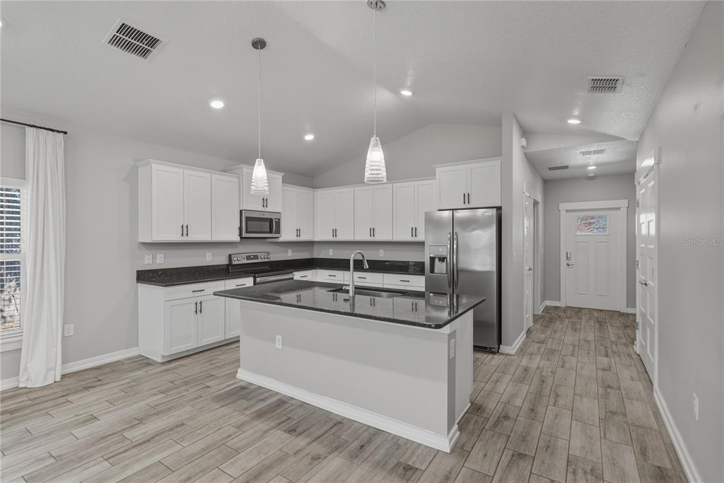 13907 9th Street Dade City, FL 33525 - Photo 10 of 43 a kitchen with stainless steel appliances granite countertop a stove and a refrigerator