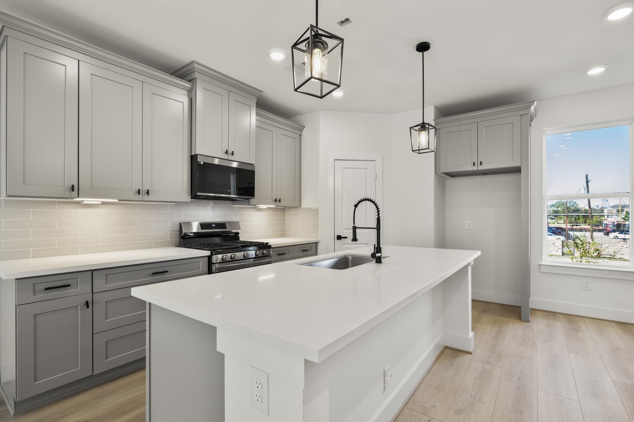 6326 Del Rio Street Houston, TX 77021 - Photo 11 of 39 a kitchen with stainless steel appliances a sink a stove a refrigerator white cabinets and wooden floor