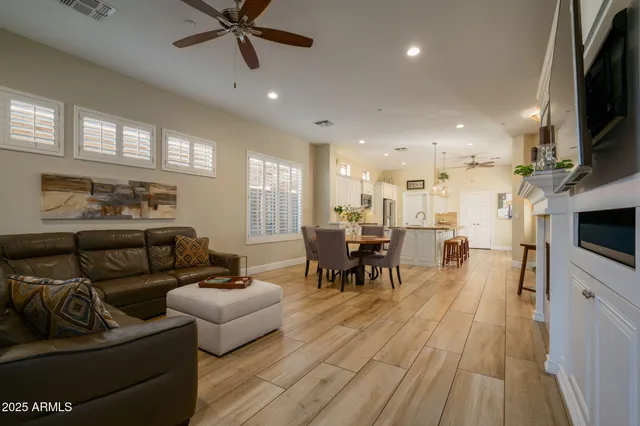 a living room with furniture and a flat screen tv with kitchen view