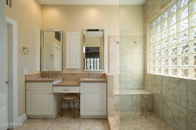 a bathroom with a granite countertop sink a mirror and a shower