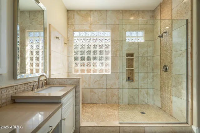 a bathroom with a shower sink and mirror
