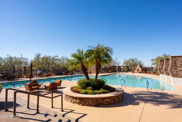 a swimming pool with outdoor seating and plants
