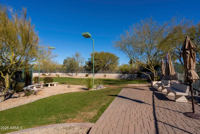 a view of a swimming pool with a patio and a yard