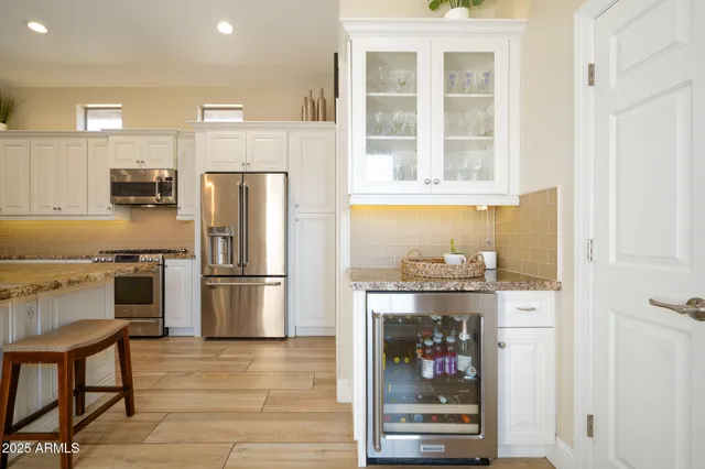 a kitchen with stainless steel appliances a refrigerator and a stove top oven