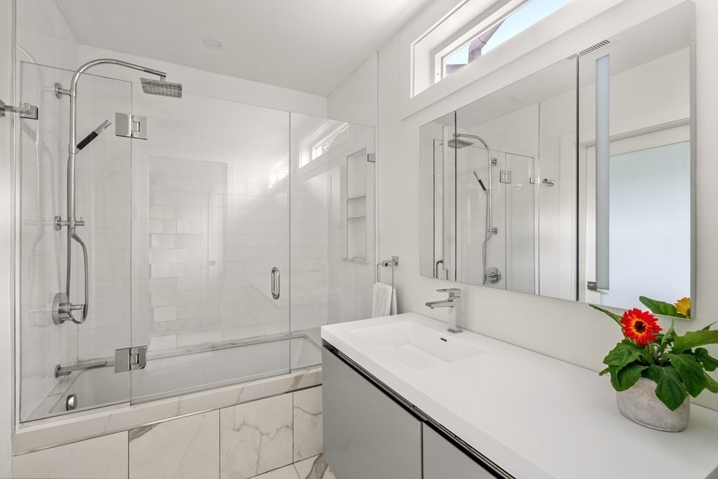 79 University Road, Unit 2 Brookline, MA 02445 - Photo 17 of 35 a bathroom with a shower sink vanity granite and shower