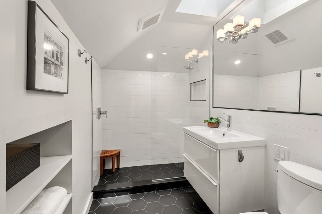 79 University Road, Unit 2 Brookline, MA 02445 - Photo 26 of 35 a bathroom with a sink a toilet and a mirror