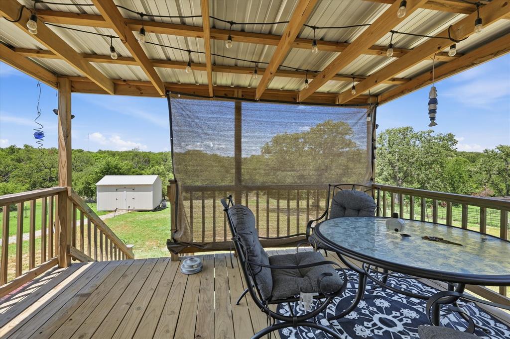 193 Firefly Drive Springtown, TX 76082 - Photo 28 of 32 Expansive outdoor deck featuring wood flooring and railings, a metal roof structure, and a partial privacy screen