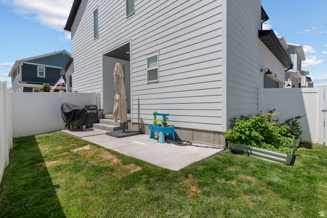1708 North 1280th Street East Payson, UT 84651 - Photo 14 of 15 Private fenced yard featuring a concrete patio, a raised metal garden bed, and a gravel foundation perimeter