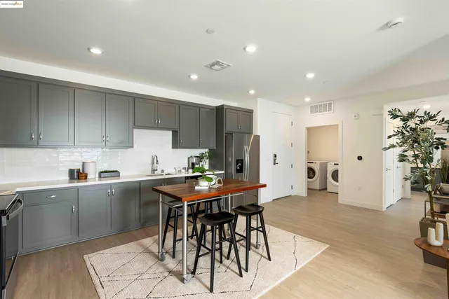 a kitchen with stainless steel appliances a table and chairs in it