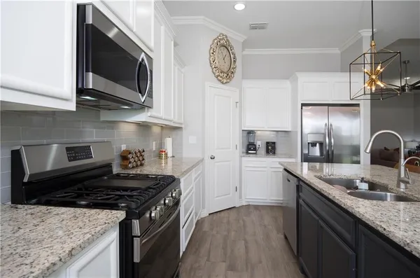 a kitchen with stainless steel appliances granite countertop a sink stove and cabinets