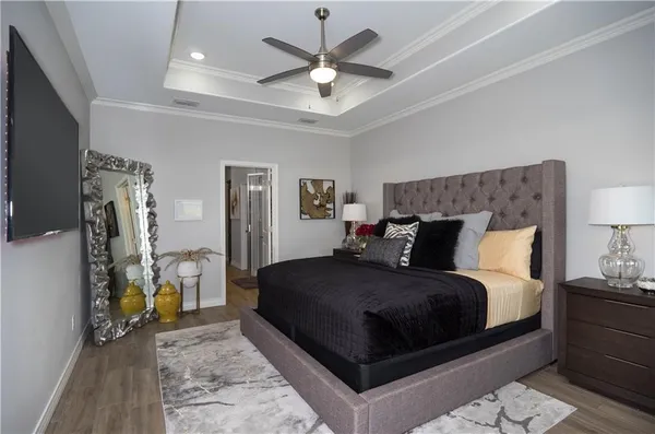 a bedroom with a bed a couch and a chandelier