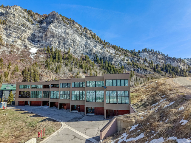9699 Bypass Road, Unit 5 Alta, UT 84092 - Photo 1 of 54 Modern multi-story building featuring extensive window-lines, a neutral-toned facade, multiple garage doors, and a paved parking area