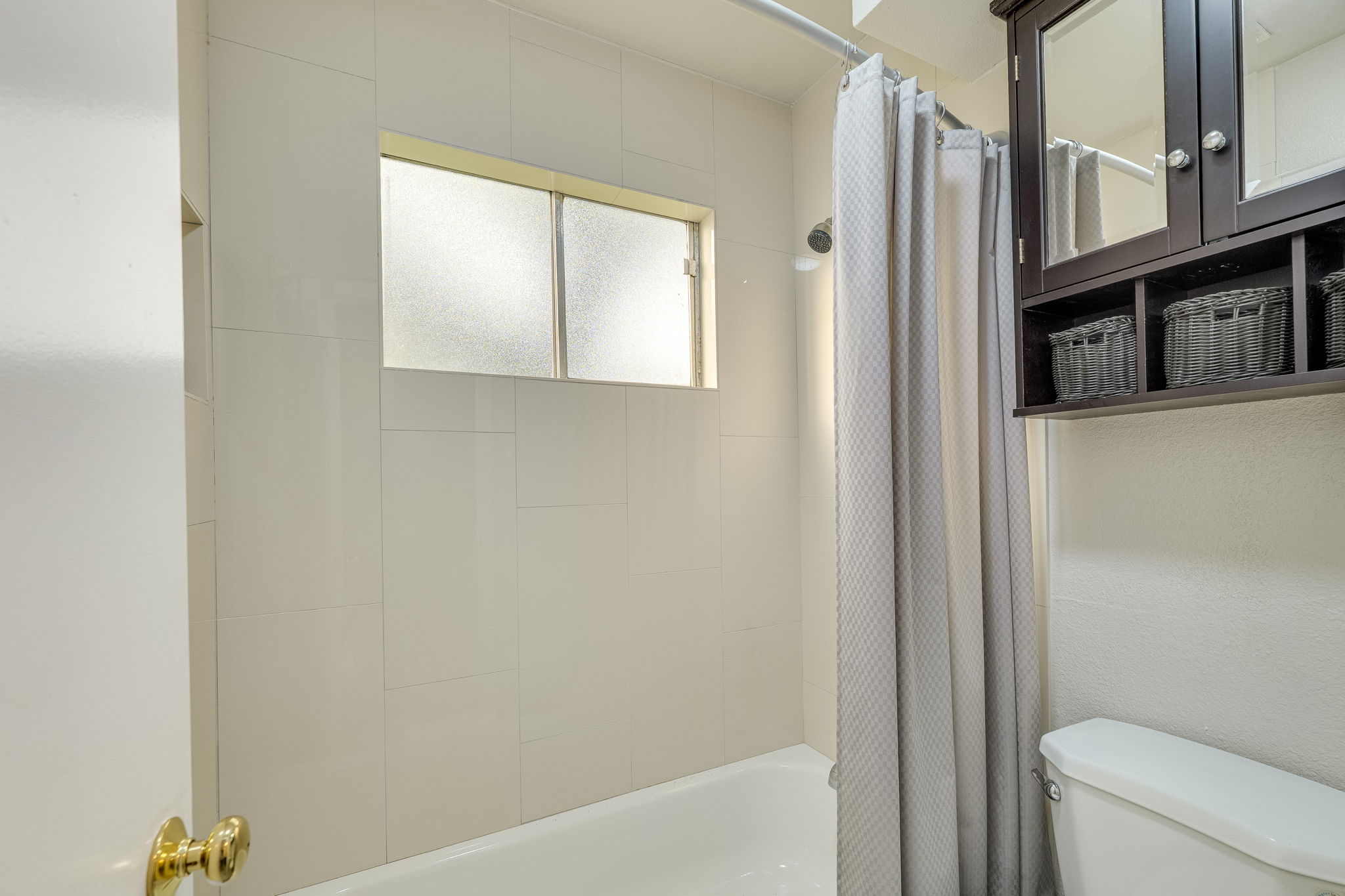 4815 Transit Circle Austin, TX 78727 - Photo 26 of 35 Primary bathroom featuring a built-in tub and shower combination with white tile surround.