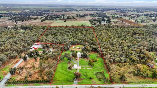 an aerial view of residential houses with outdoor space and trees