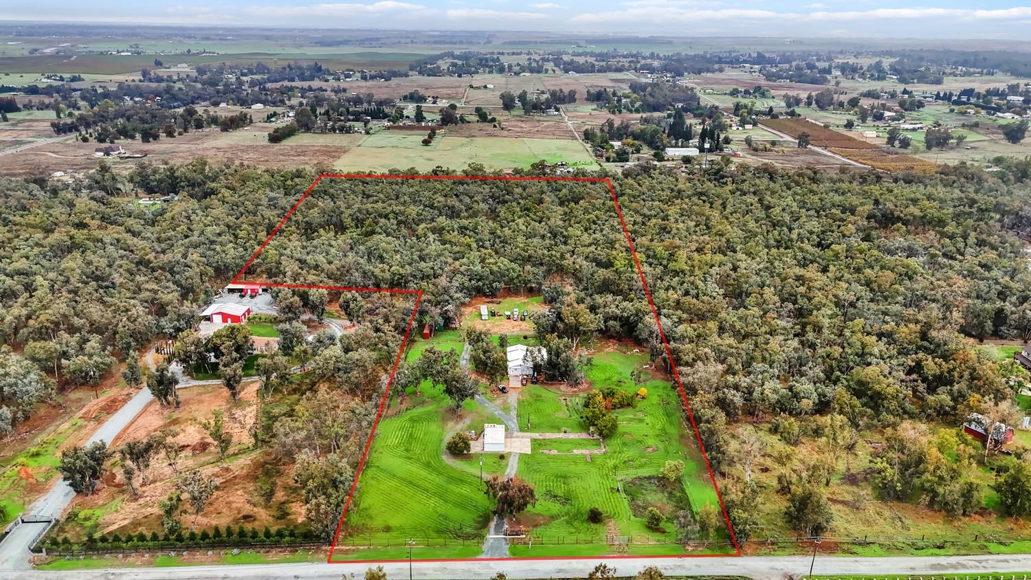 an aerial view of residential houses with outdoor space and trees